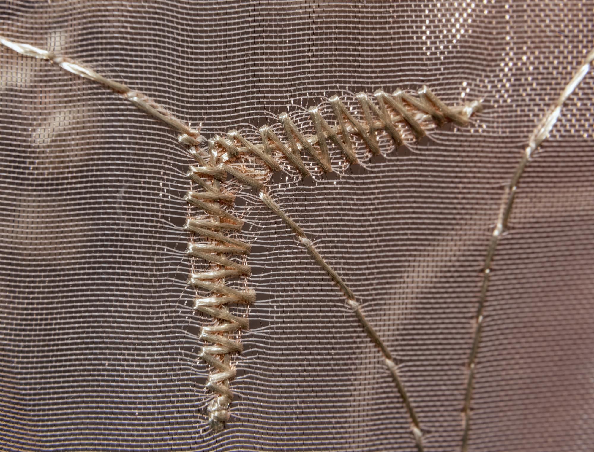 Nahaufnahme von Stickstichen in metallischem Garn